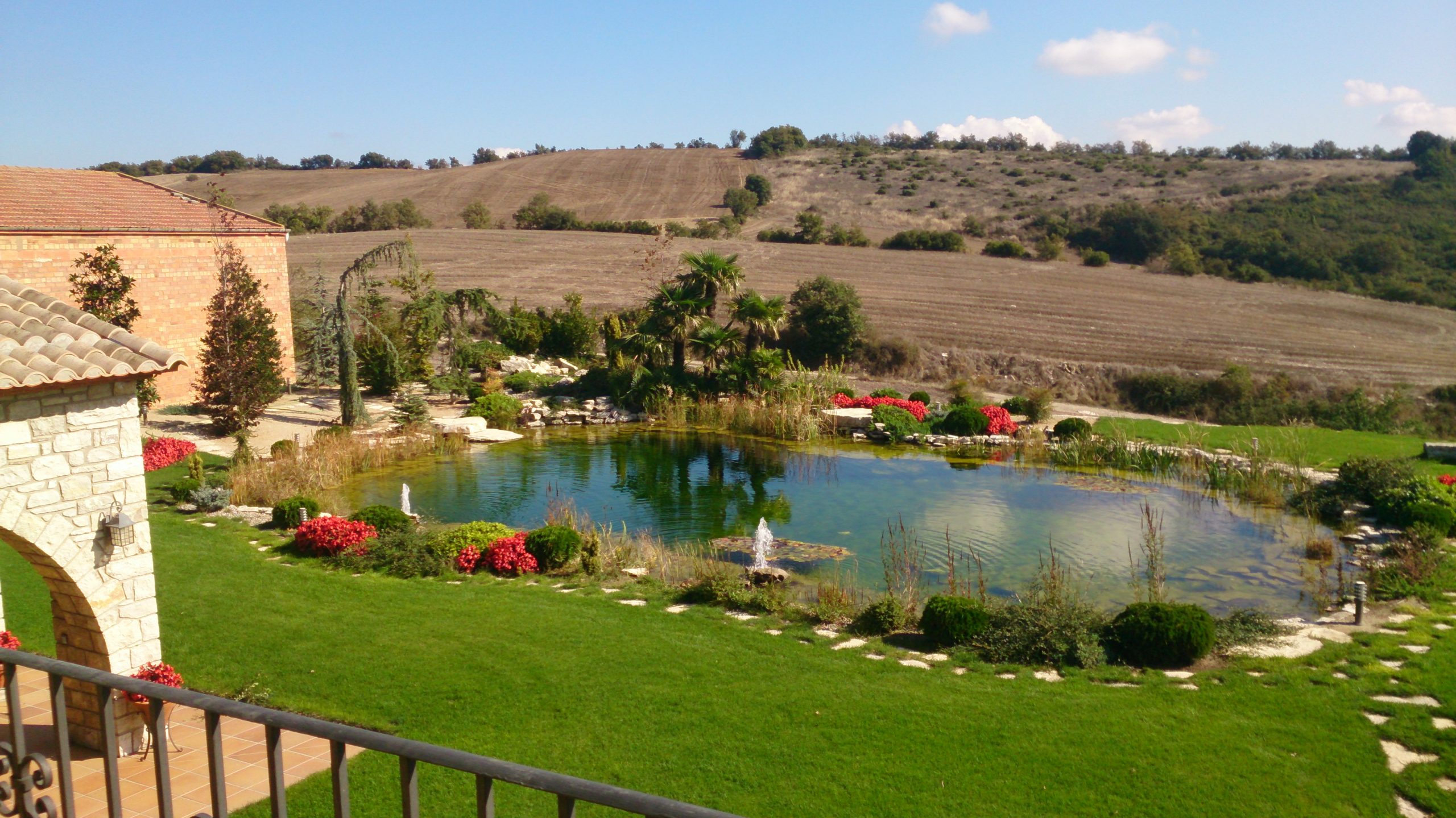 lago natural en Calaf integrado en jardín con vegetación y rocas